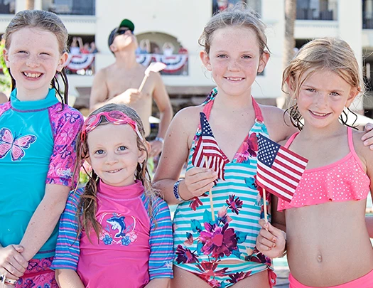 a group of girls in swimsuits holding flags