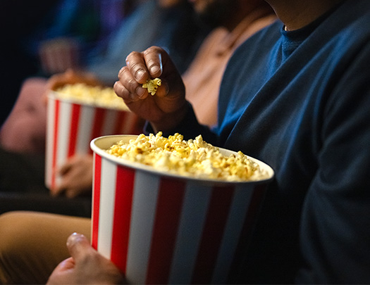 a person holding buckets of popcorn