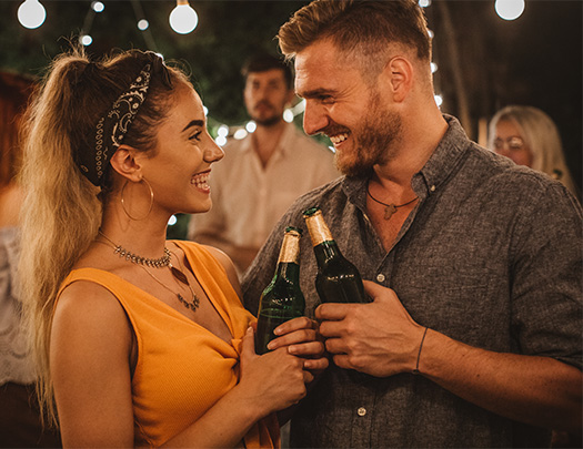 a man and woman holding bottles of beer
