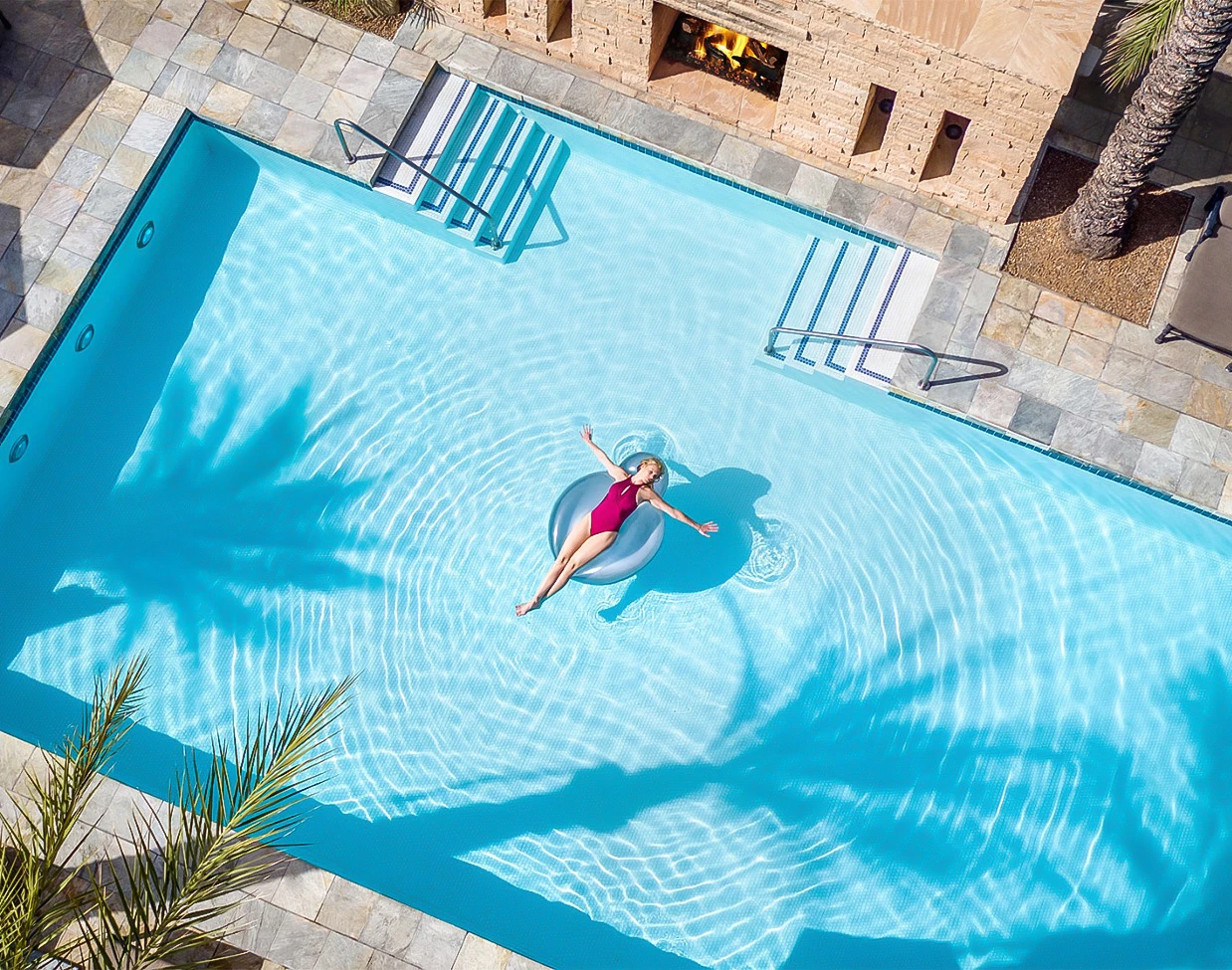a woman floating on a donut in a pool