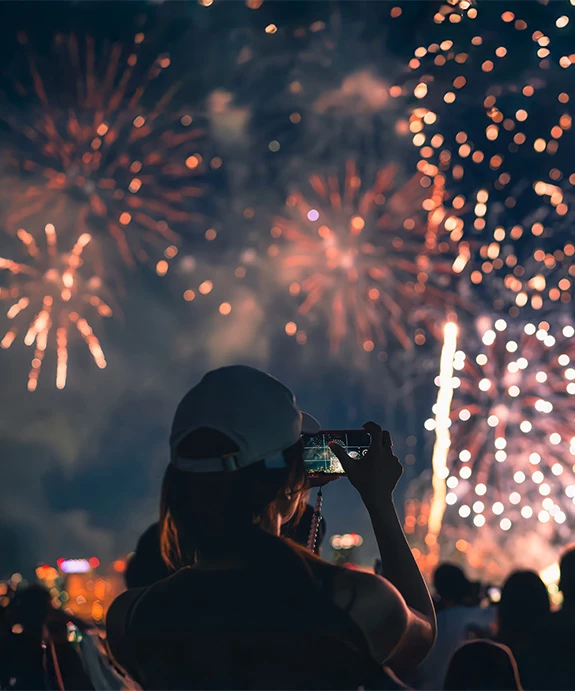 a woman taking a picture of fireworks