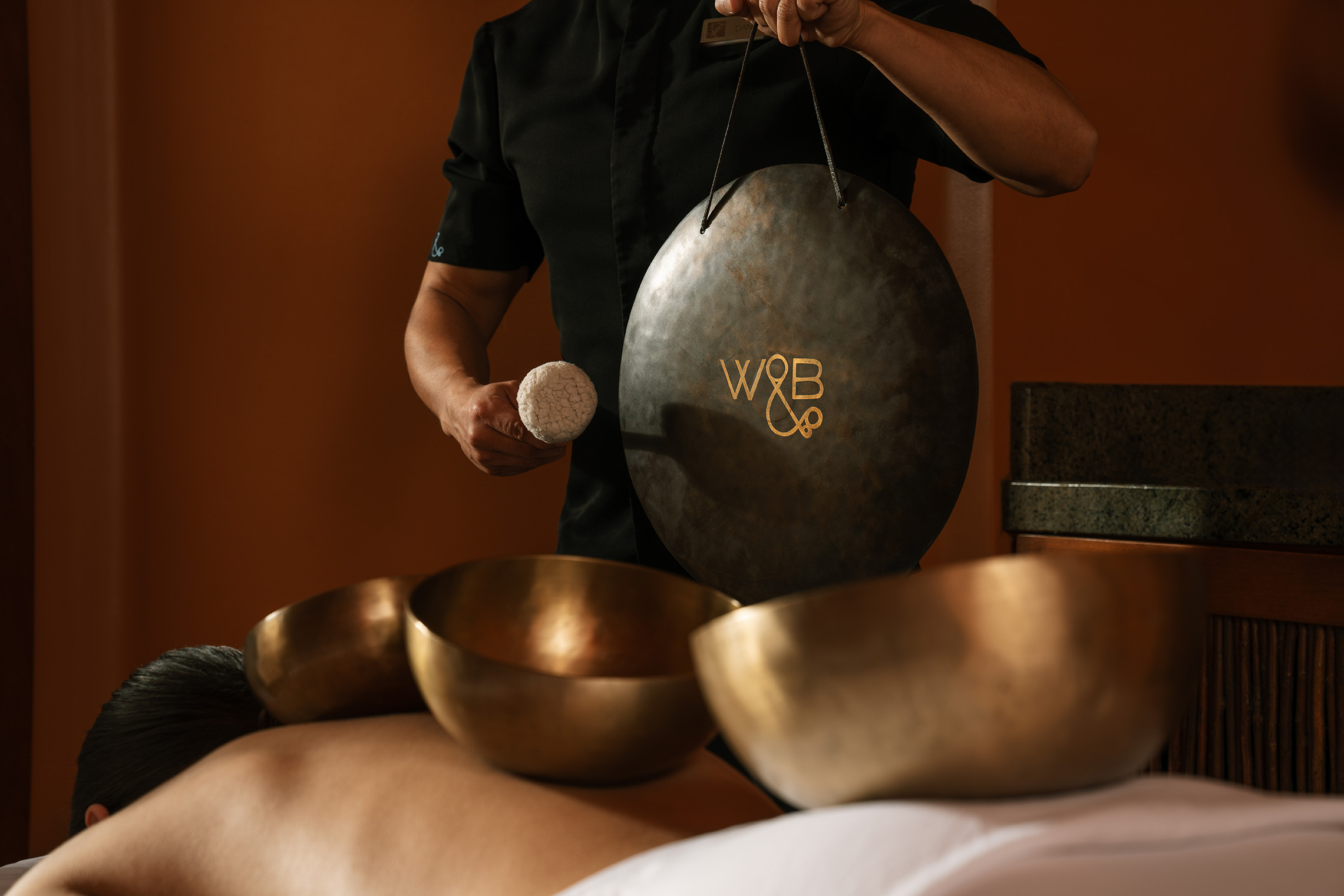 a person holding a gong over a group of bowls