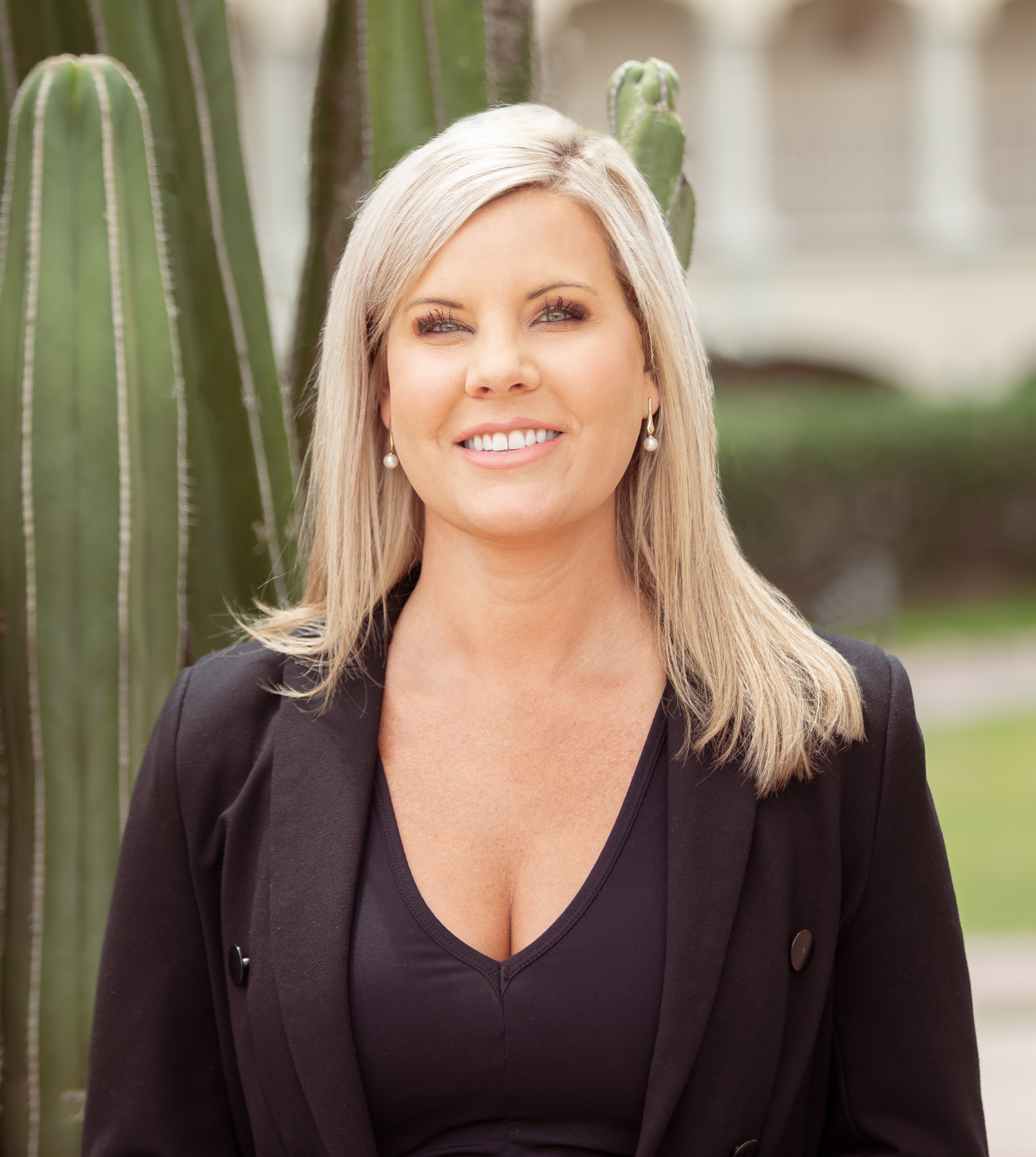 a woman smiling in front of a cactus