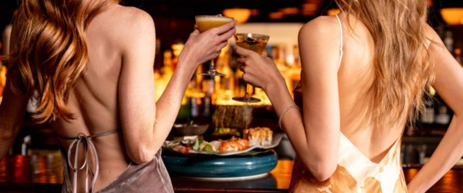 a couple of women holding drinks