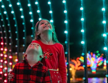 a boy and girl looking up at lights