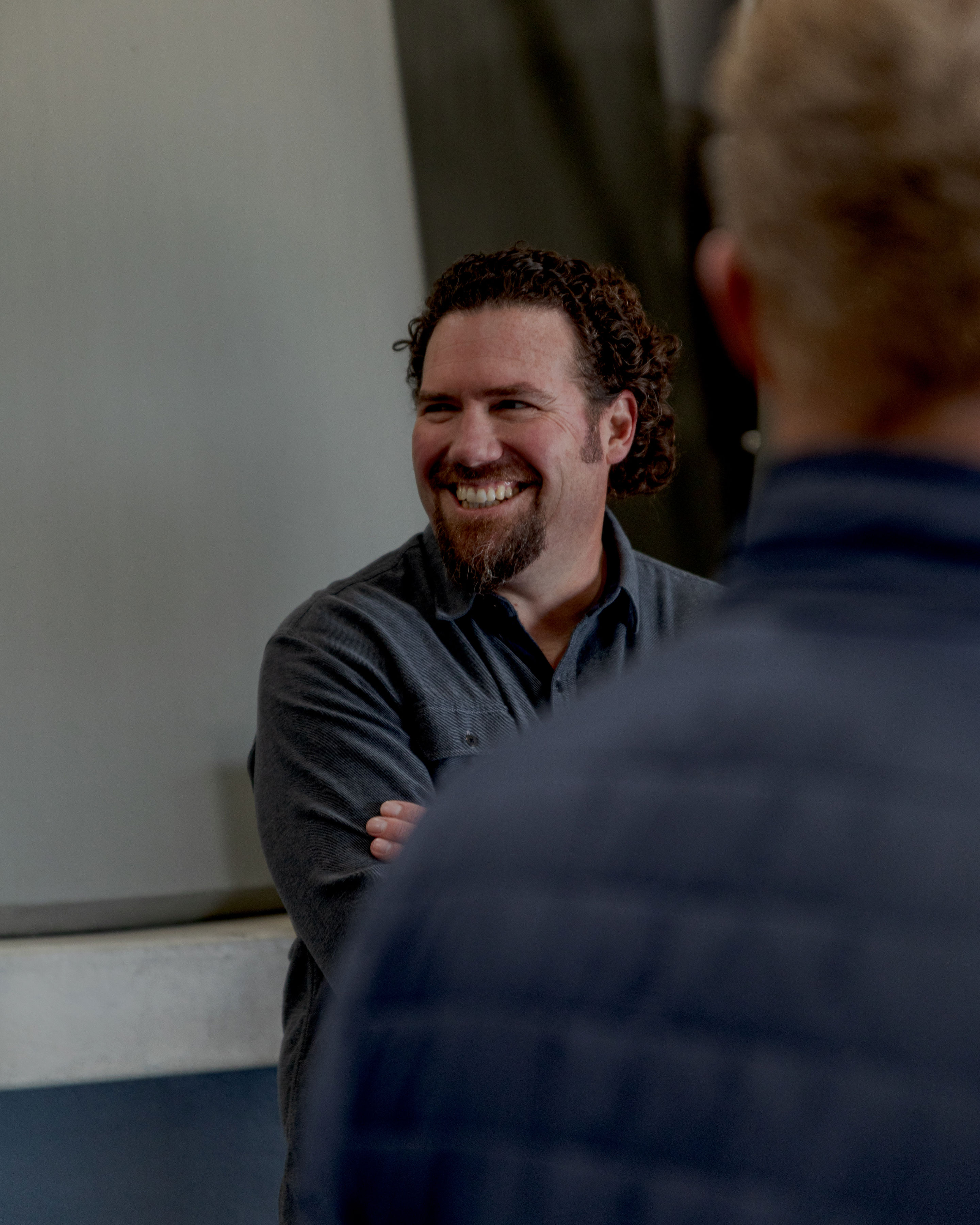 a man smiling with his arms crossed
