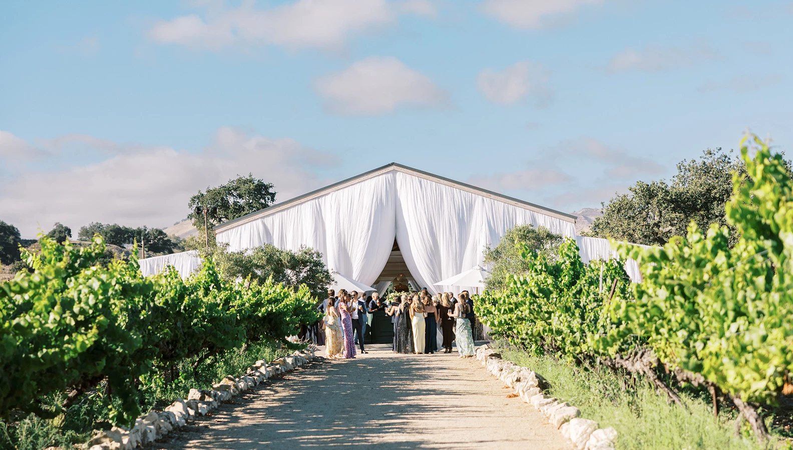 a group of people walking in front of a white tent