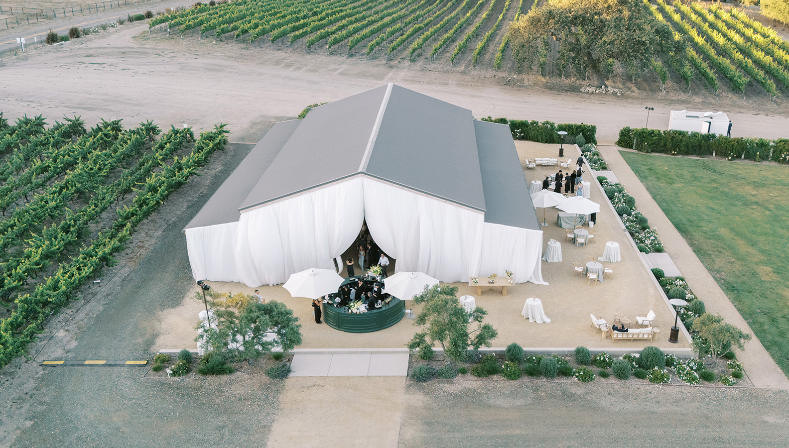 a large white tent with white curtains and tables and chairs