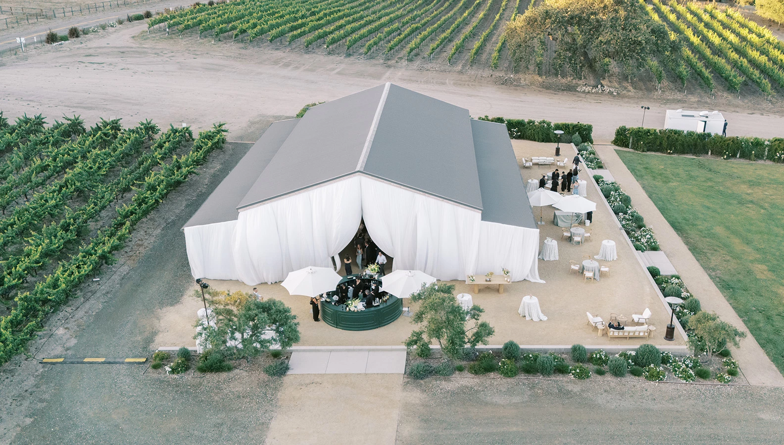a large white tent with white curtains and tables and chairs