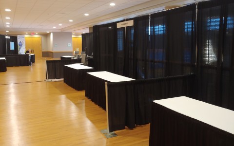 a room with black curtains and tables