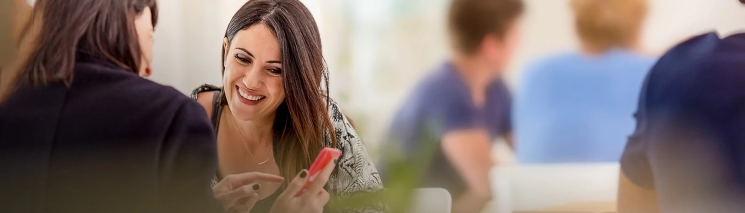 two ladies looking at the same thing on a phone