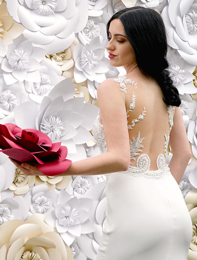 bride taking photos in front of floral-inspired decor