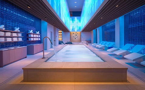a large indoor pool with a large tub and chairs