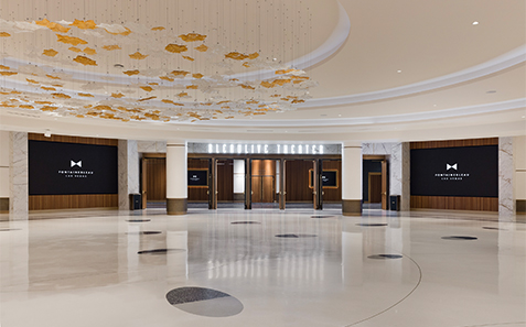 a large room with white columns and gold ceiling