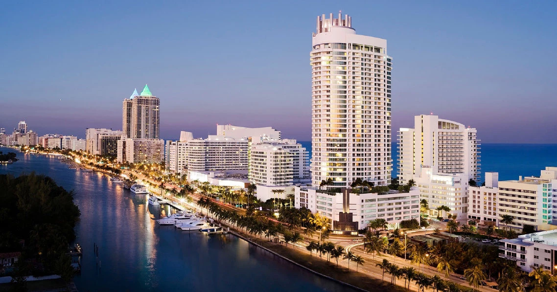 General view of large white buildings next to the sea, on a sunset
