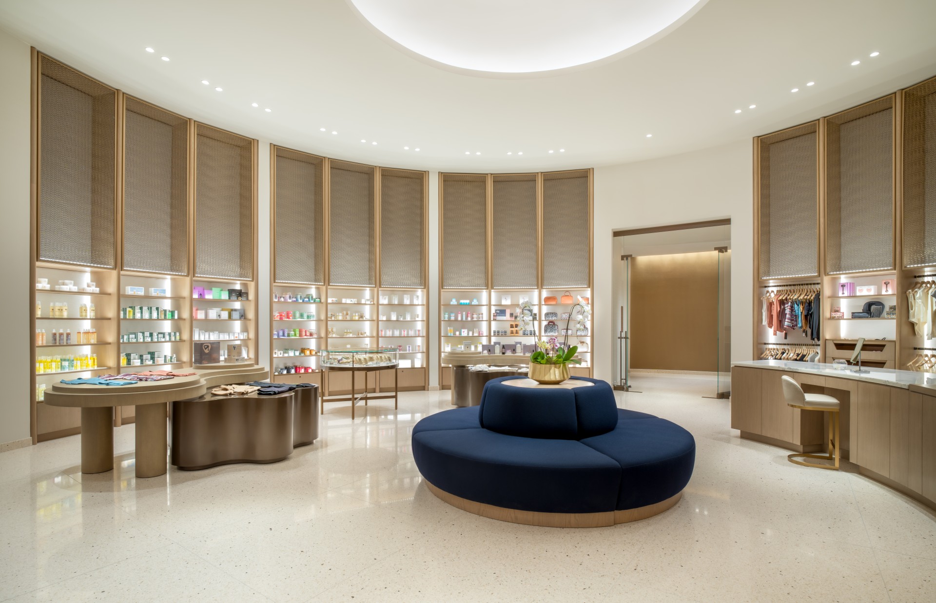 a store with a round blue couch and shelves with a plant on top