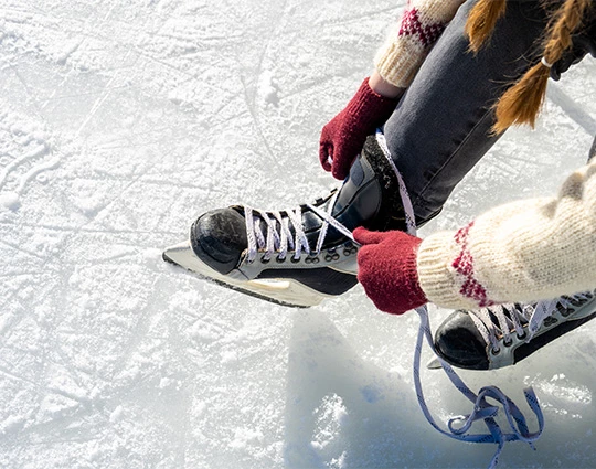 a person tying a shoelace on ice