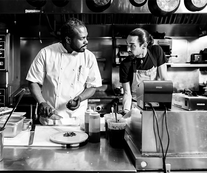a couple of chefs in a kitchen