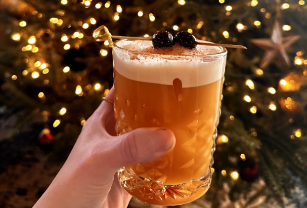 a hand holding a glass of liquid