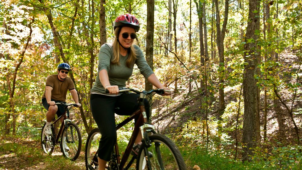 a woman riding a bike in the woods
