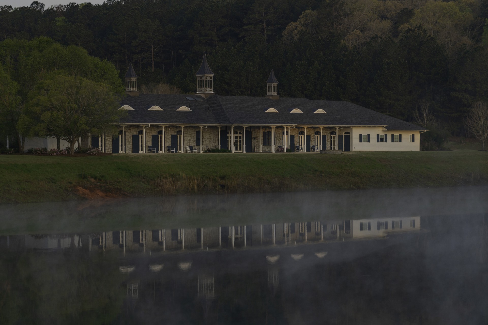 a building with a lake and trees in the background