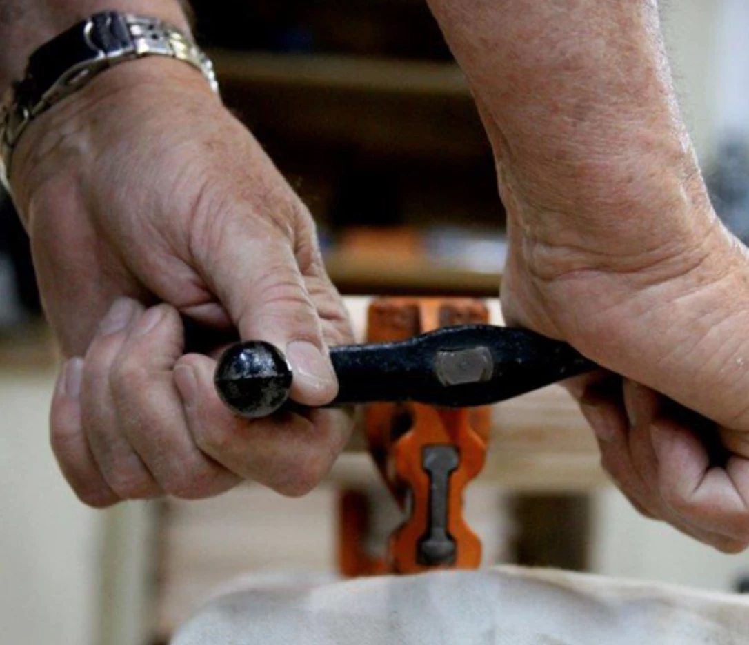 a close-up of a man's hands holding a black tool