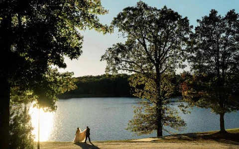 a man and woman walking by a lake