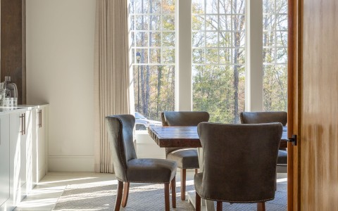 a table and chairs in a room with windows