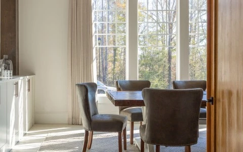 a table and chairs in a room with windows