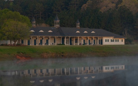 a building with a lake and trees in the background