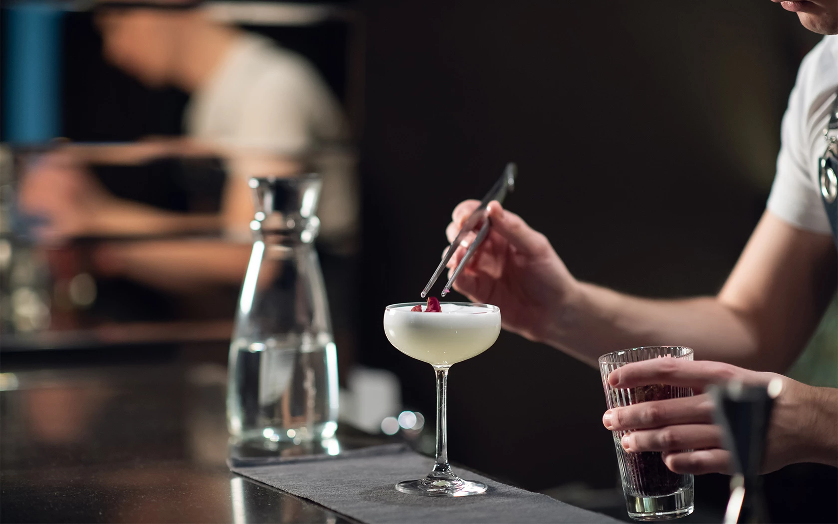 a person garnishing a drink