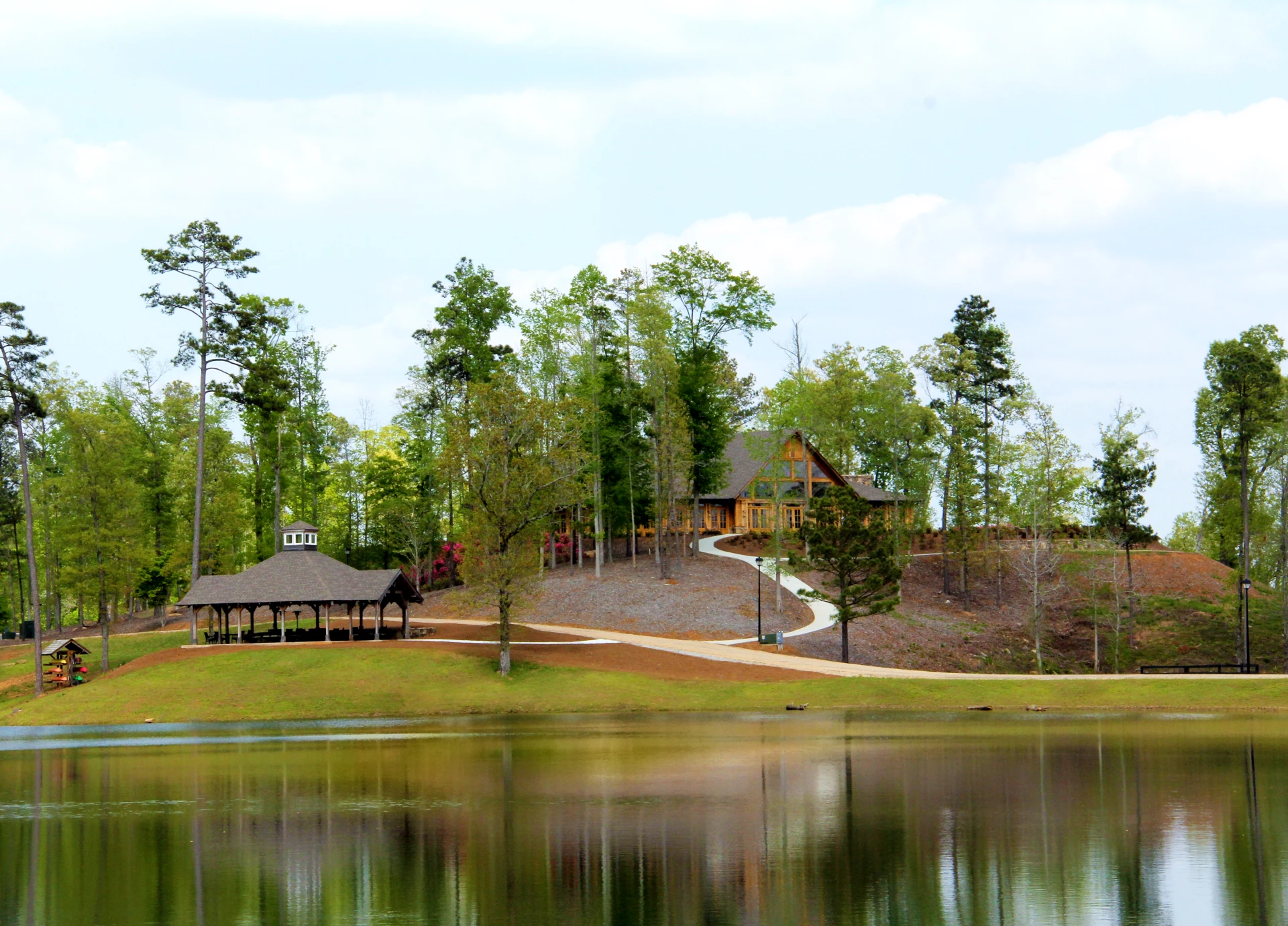 a house on a hill with trees and a lake