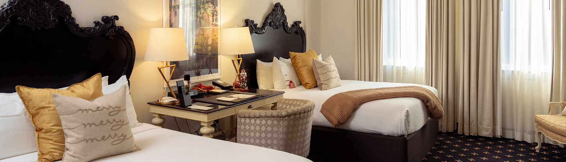 a bed with pillows next to a desk