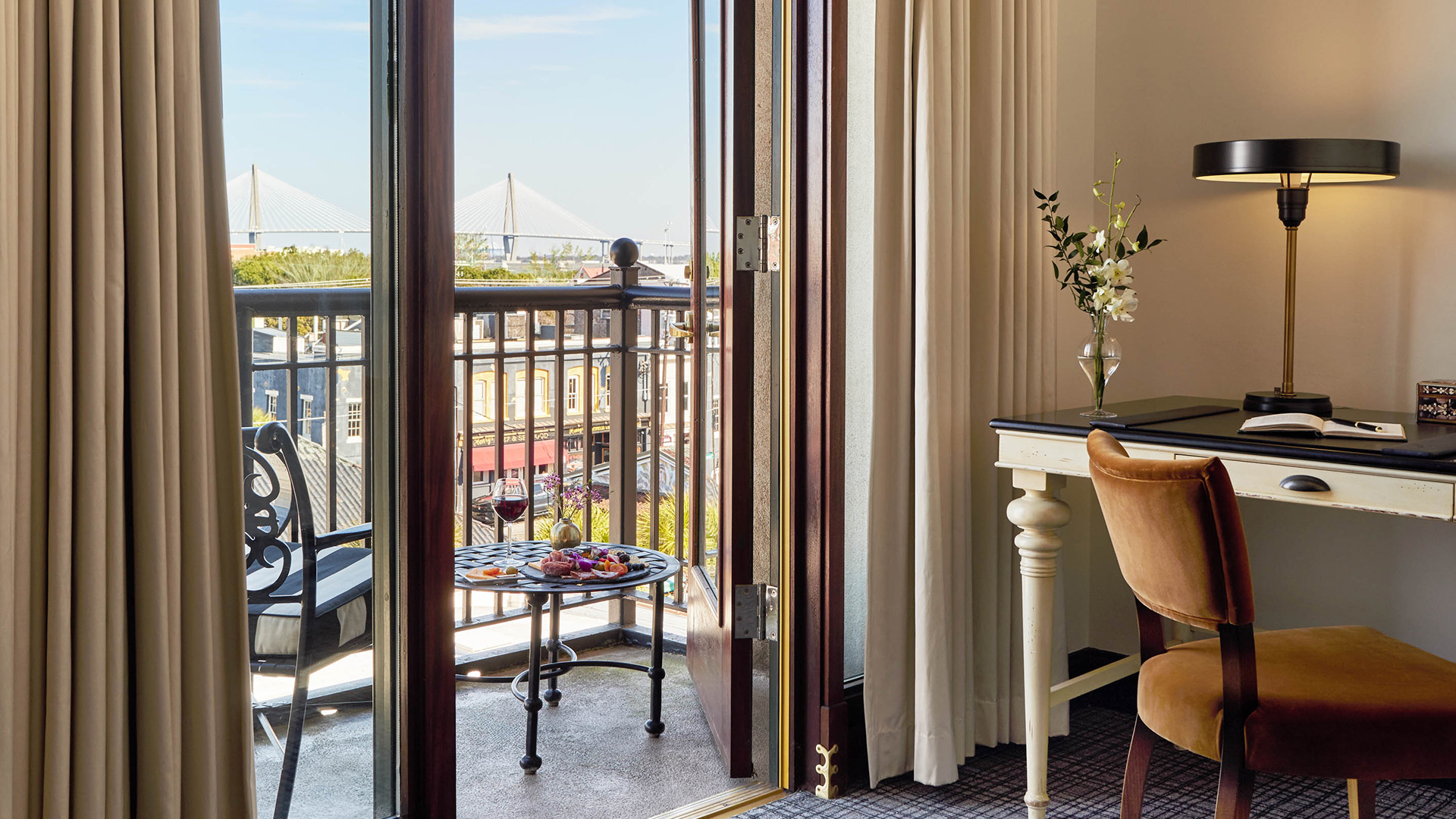 a room with a balcony and a table and chairs
