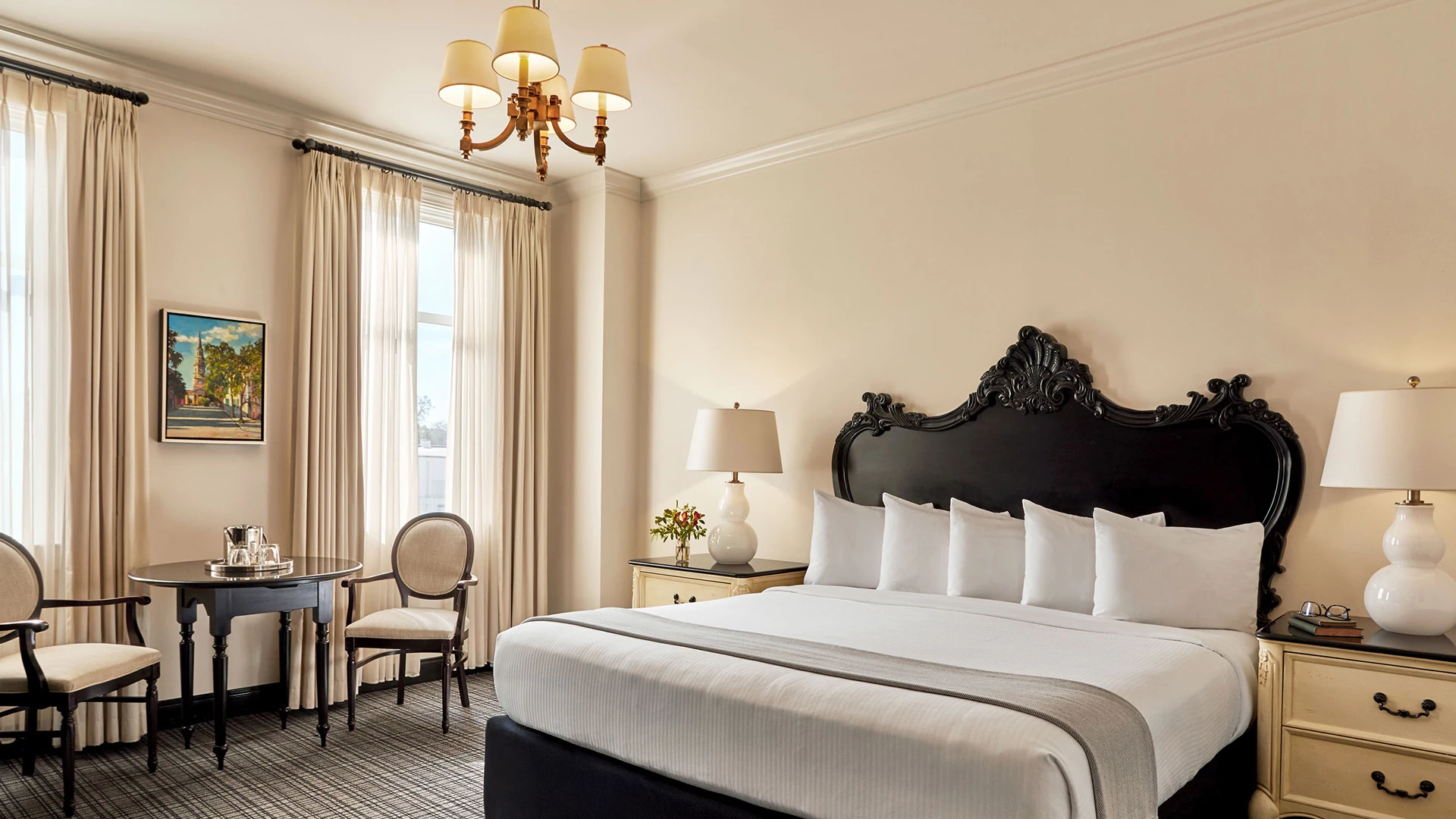 a room with a bed and chairs