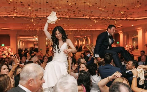 a woman in a white dress sitting on a chair in front of a crowd of people
