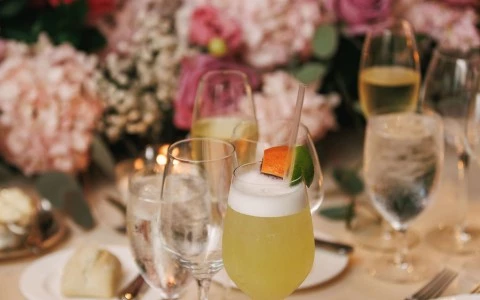 a table with glasses of drinks and flowers