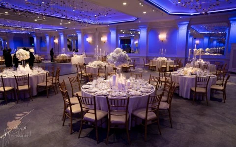 a large round banquet table set up with white tables and candles