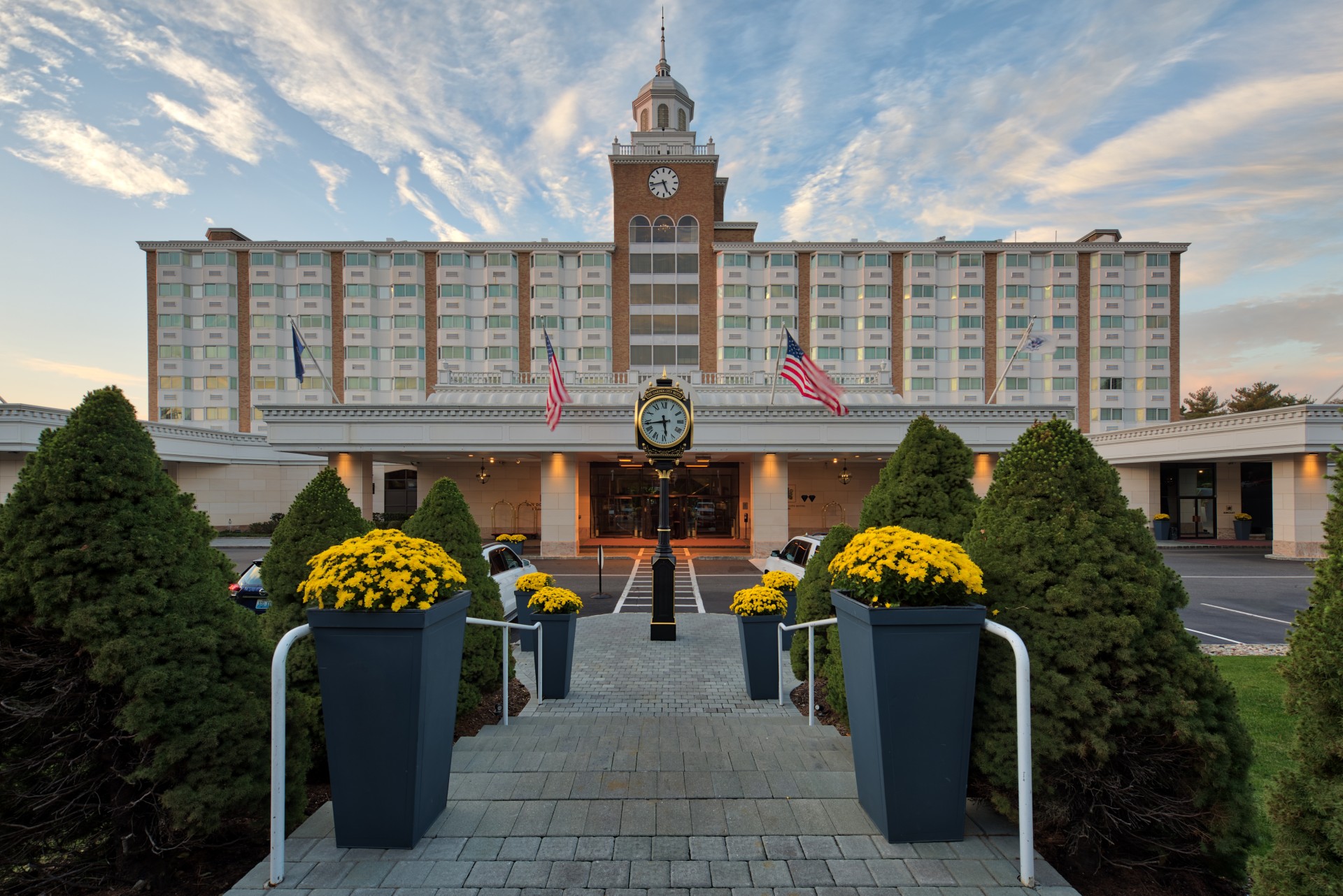 a large building with a clock and flowers