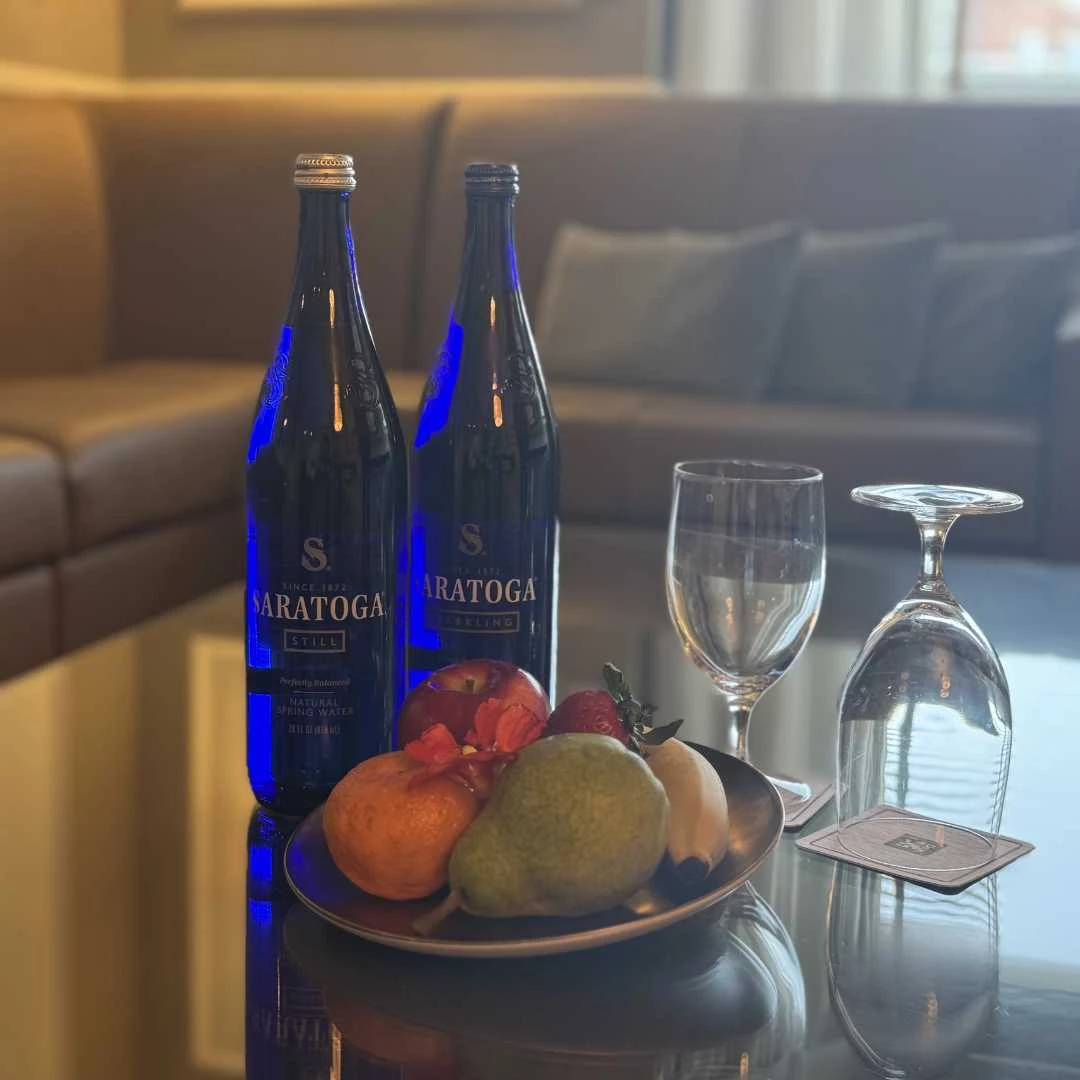 a plate of fruit and wine glasses on a table