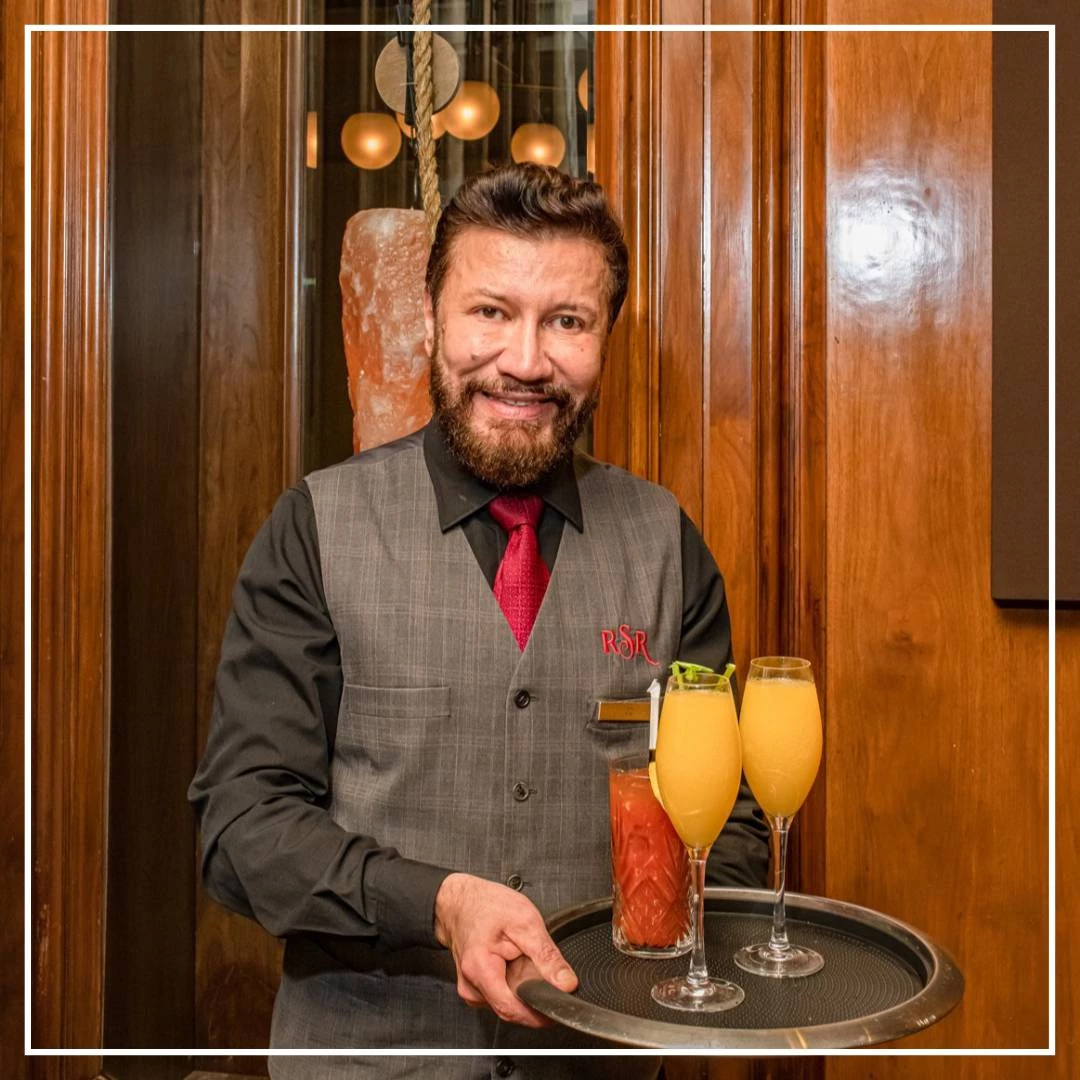 a man holding a tray with drinks