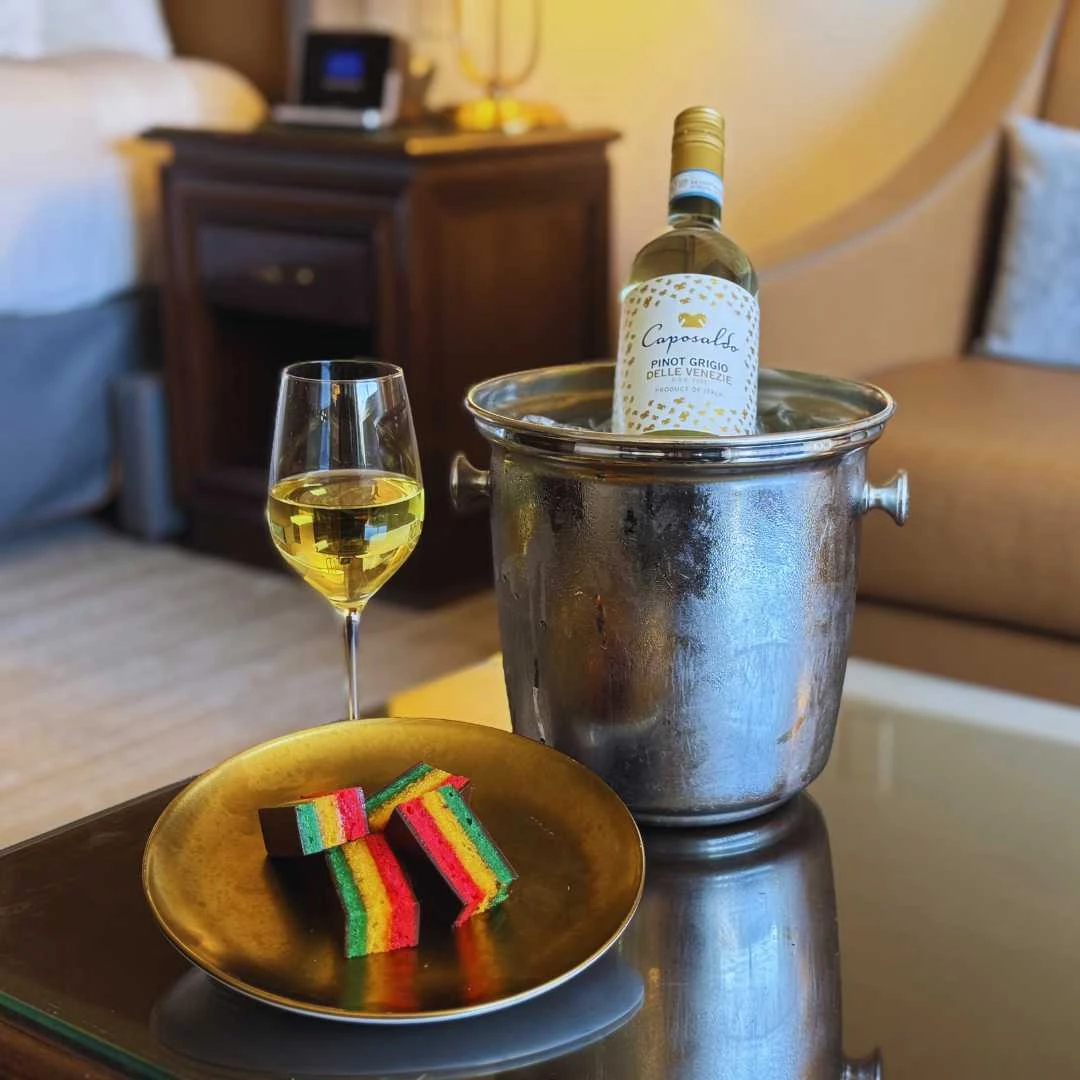 a bottle of wine in a bucket with a plate of food and a glass of wine