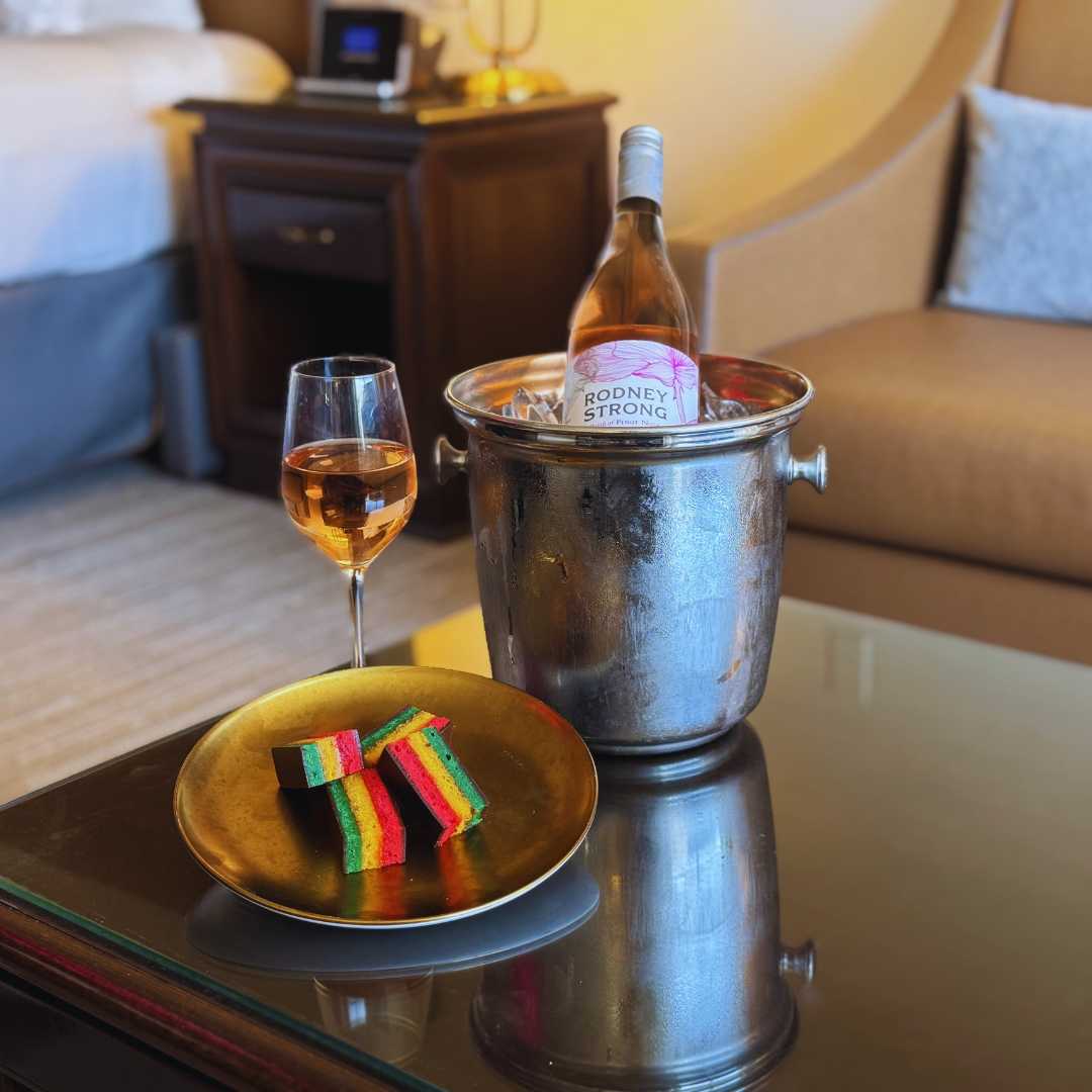 a bottle of wine in a bucket and a plate of food on a table