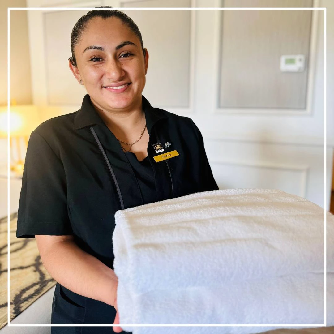 a woman holding a stack of towels
