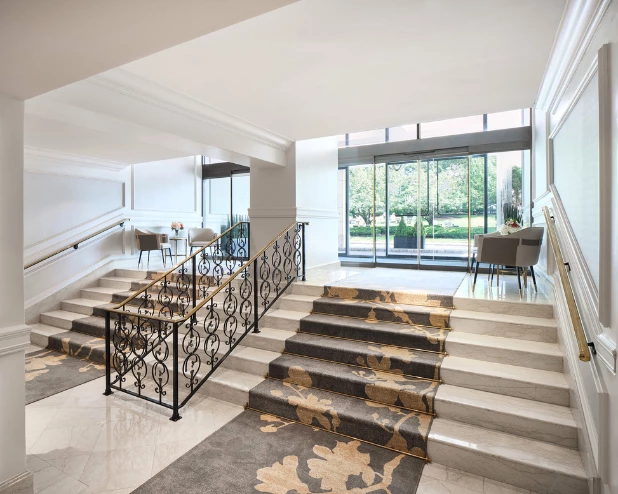 a staircase with a black railing and a black and gold carpet