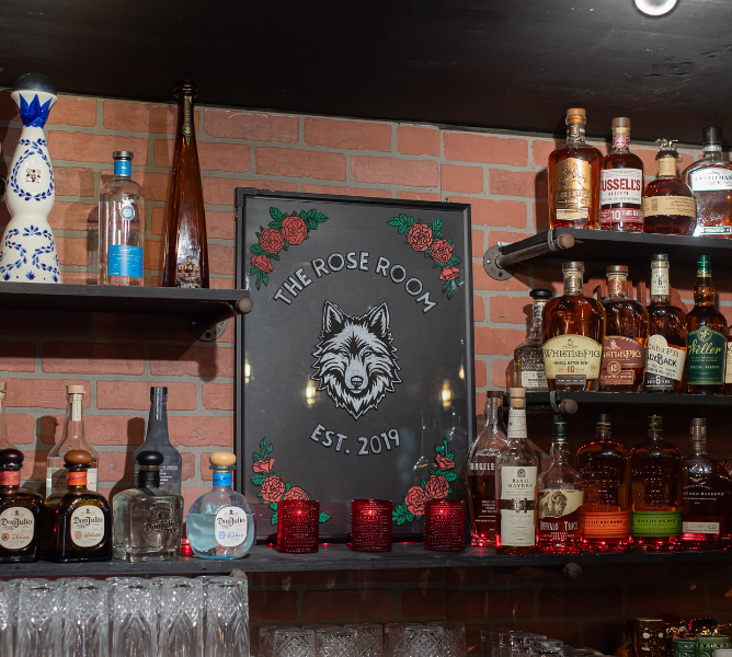 a shelf with bottles of alcohol and glasses on it