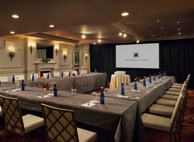 a large room with a large screen and tables