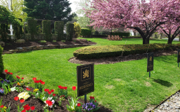 a lawn with a sign and flowers