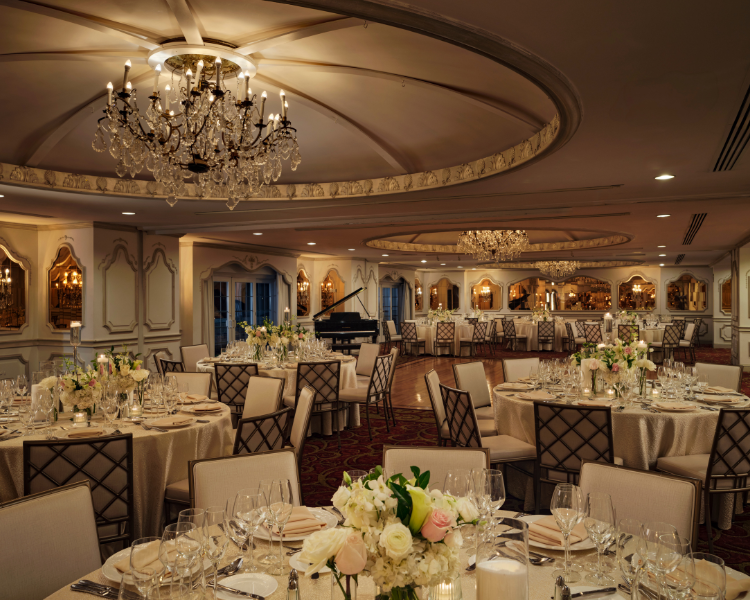 a room with tables and chairs and chandeliers