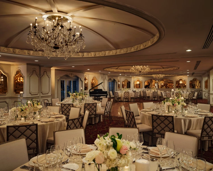 a room with tables and chairs and chandeliers